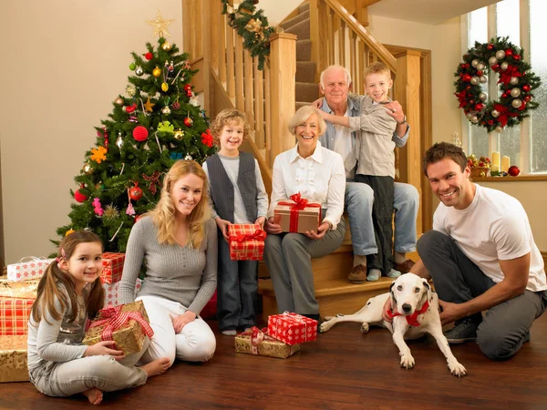 Family with gifts in front of Christmas tree