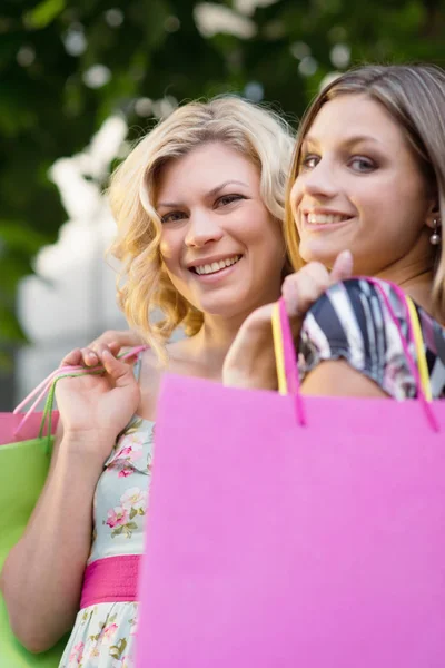 二人の幸せな若い女性の買い物袋に笑みを浮かべて肖像画 — ストック写真