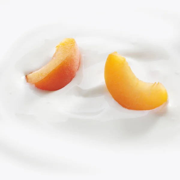 新鲜切好的桃片轻轻放在新鲜的酸奶上 — 图库照片