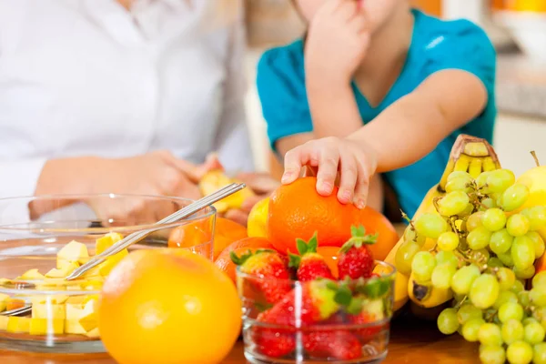 健康的な食事 果物の異なる種類のキッチンに座っている母親と子供 — ストック写真