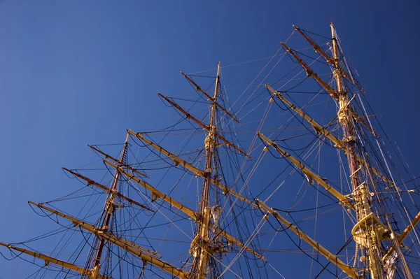蓝色的蓝天映衬着一艘旧木船上的黄色桅杆 — 图库照片