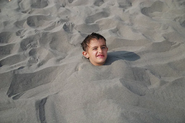 被埋在沙子里的快乐孩子 — 图库照片