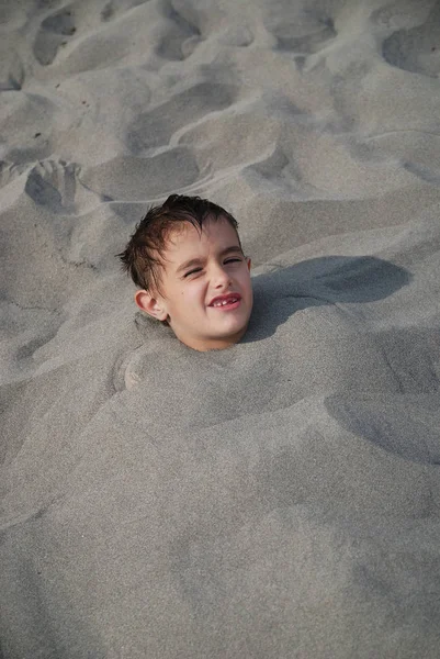 被埋在沙子里的快乐孩子 — 图库照片