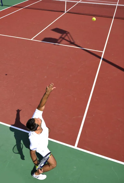 Ung Man Spela Tennis Utomhus Orange Tennisbana Tidigt Morgonen — Stockfoto