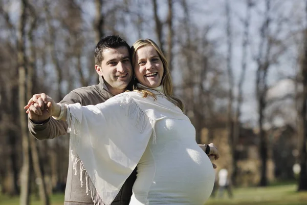 幸せな若い夫婦屋外で自然の中で楽しいと赤ちゃんを待っており 若い家族の成長と妊娠の概念を表す — ストック写真
