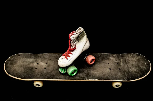 ヴィンテージスタイルブラックスケートボードと暗い背景のスケートブーツ — ストック写真