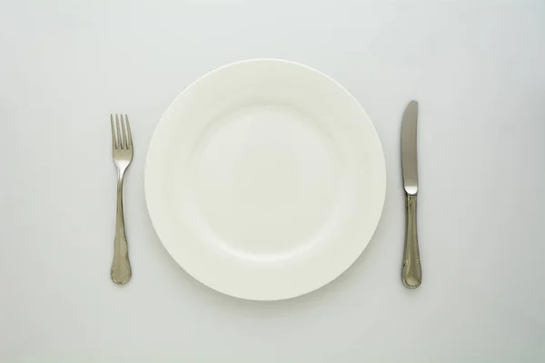 Άδειο Πιάτο Πιρούνι Και Μαχαίρι Λευκό Φόντο — Φωτογραφία Αρχείου