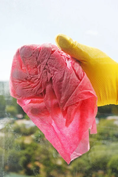 用湿布把黄色橡胶手套洗窗玻璃 — 图库照片