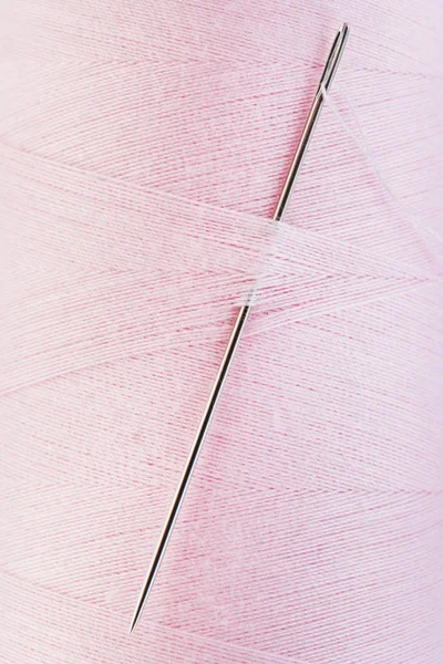 ピンクの糸のスプールで手縫い針を閉じる — ストック写真