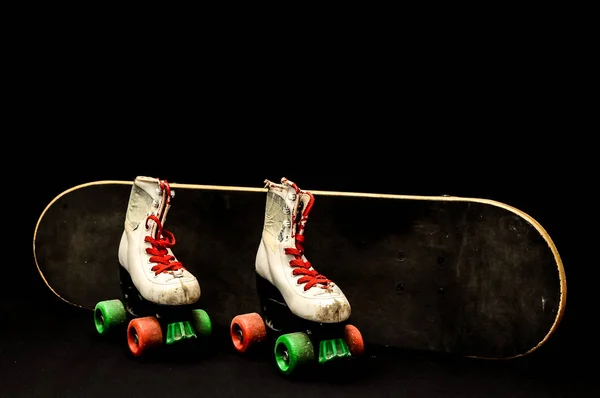 老式风格的黑色滑板和黑暗背景下的溜冰鞋 — 图库照片
