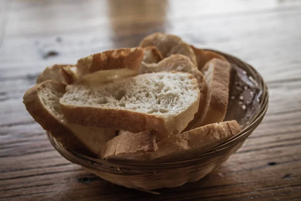 木製のテーブルの上のプレートにスライスしたパン背景 — ストック写真