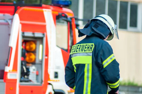 Back Fireman Helmet His Emergency Vehicle Landscape — Stock Photo, Image