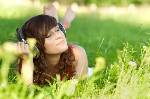 Молодая Женщина Слушает Музыку Траве Стоковое Изображение