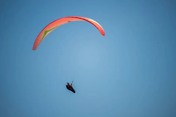 鮮やかな青い雲のない空にオレンジのグライダーとハンググライダー — ストック写真