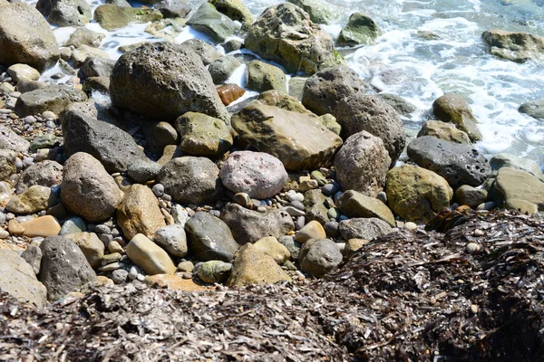 ビーチや灰色の岩に石を敷き — ストック写真
