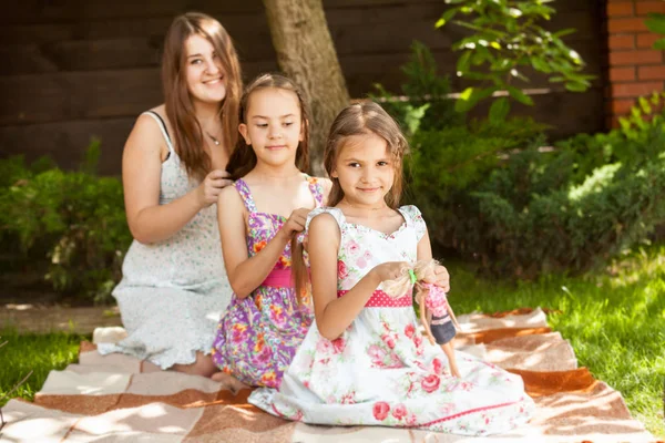 Outdoor Shot Mother Braiding Hair Two Daughters Grass Park — Stock Photo, Image