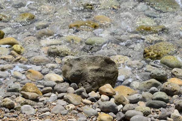 ビーチや灰色の岩に石を敷き — ストック写真