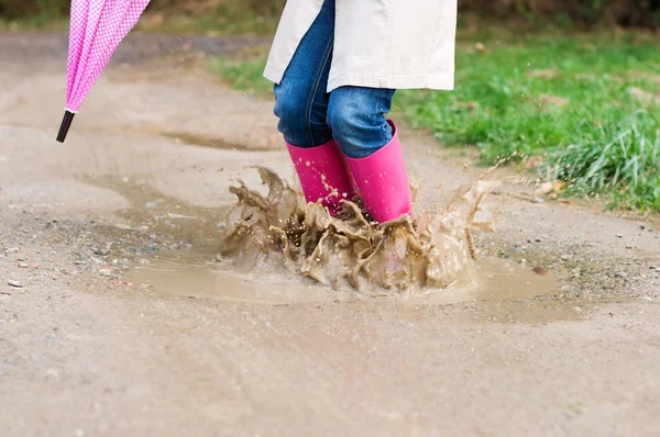 Junge Frau Mit Gummistiefeln Springt Pfütze — Stockfoto