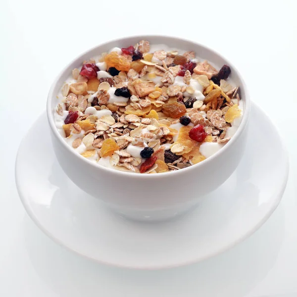 おいしい朝食のボウル健康的な栄養価の高い食事のための白いセラミックボウルに提供されるドライフルーツやナッツと混合オート麦フレークとムーズリー — ストック写真