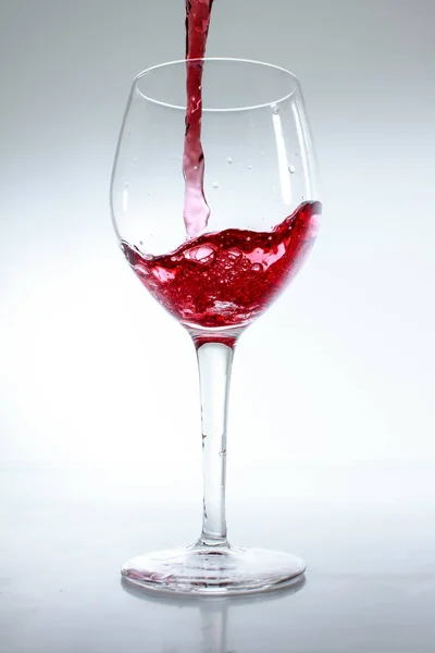 Rött Vin Hälls Ett Glas Vit Bakgrund — Stockfoto