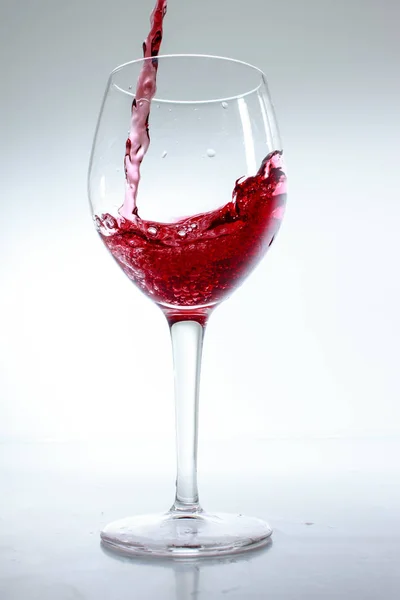 Rött Vin Hälls Ett Glas Vit Bakgrund — Stockfoto