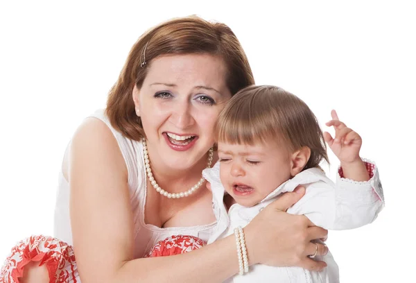 カメラで笑う母の腕に抱っこされ泣きながら動揺している幼い赤ちゃん — ストック写真