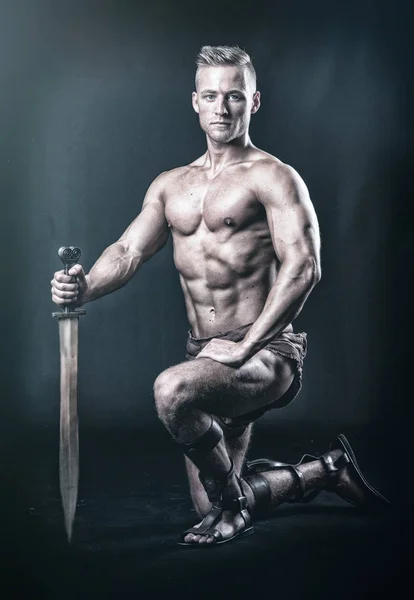 a muscular man with a sword in pose