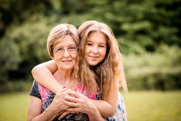 Senior Sonriente Mujer Abrazada Por Nieta Aire Libre Naturaleza — Foto de Stock