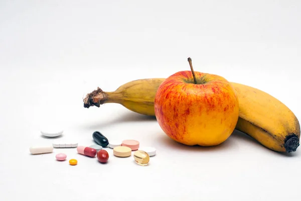 様々なカラフルな錠剤リンゴとバナナ — ストック写真