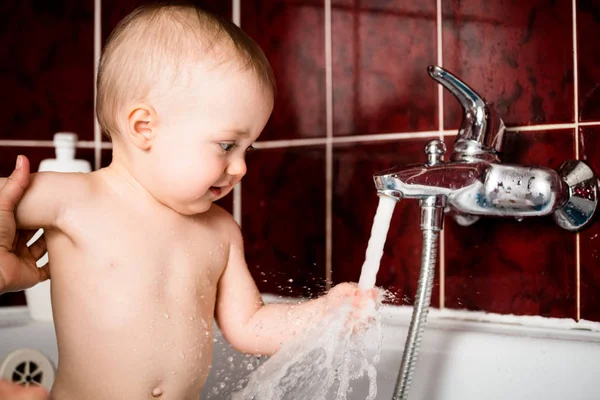 可爱的小宝宝在浴室里玩水龙头 — 图库照片