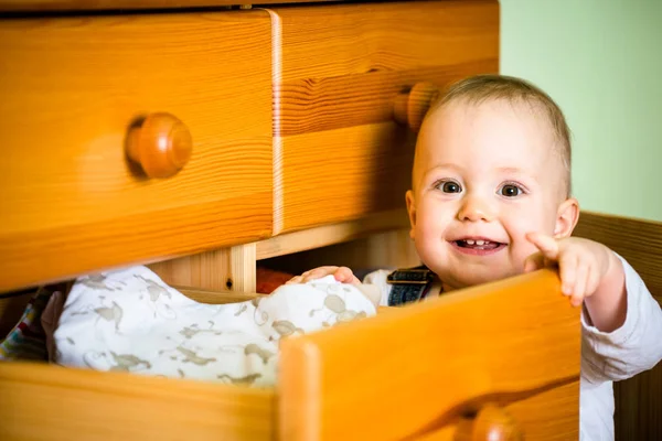 Baby Membuka Laci Dengan Pakaian Pada Furnitur Kayu Rumah — Stok Foto