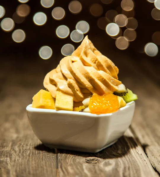 白碗放在木桌上的蛋白果片上的巨口美白黄冻酸奶 — 图库照片