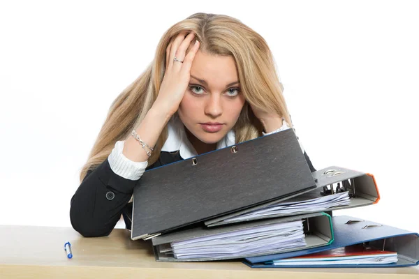 年轻的女人坐在办公桌前翻阅着一堆文件 看上去很沮丧 — 图库照片