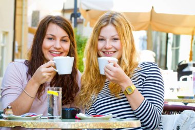 two young women in street cafe clipart