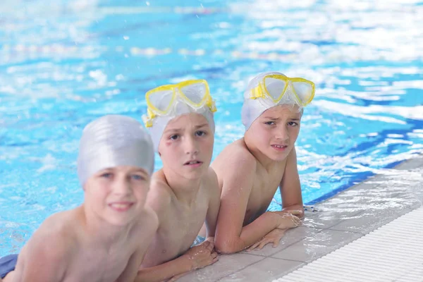 水泳プールのクラスで水泳を学ぶ幸せな子供たちのグループ — ストック写真