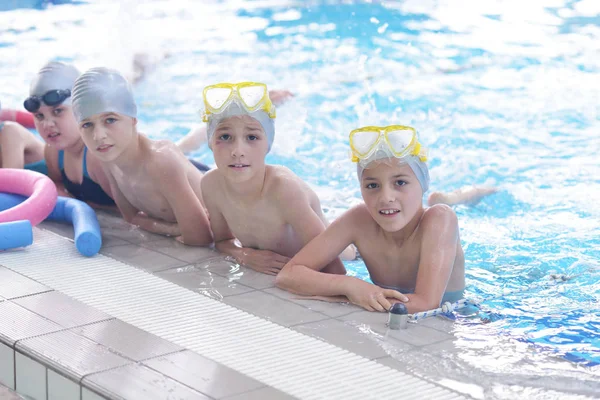 水泳プールのクラスで水泳を学ぶ幸せな子供たちのグループ — ストック写真