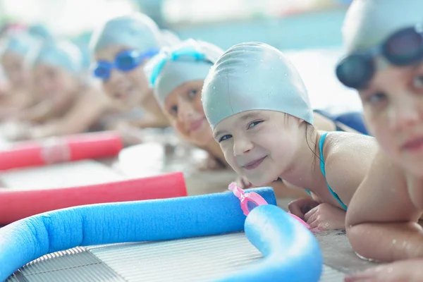 水泳プールのクラスで水泳を学ぶ幸せな子供たちのグループ — ストック写真