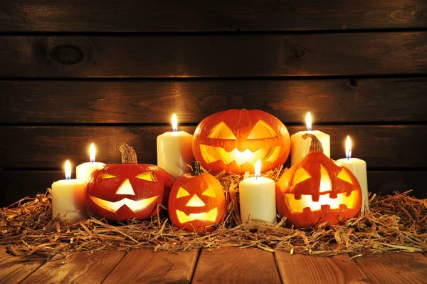 Four Lighted Halloween Pumpkins Candles Straw Old Weathered Wooden Boards — Stock Photo, Image