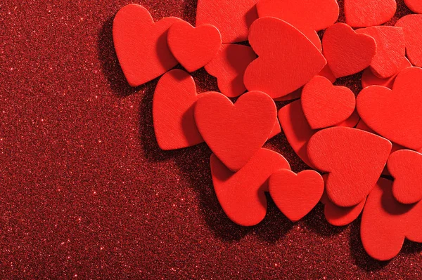 Many Small Red Wooden Heart Red Glitter Background — Fotografia de Stock