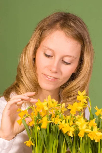 水仙の花を持つ若い女 — ストック写真