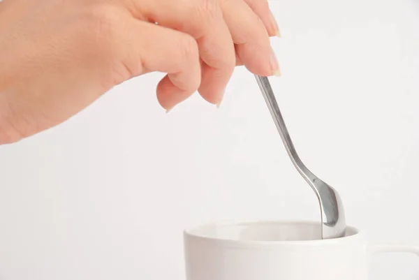 Kézfogás Kanál Egy Csésze Kávé Fehér Háttér — Stock Fotó