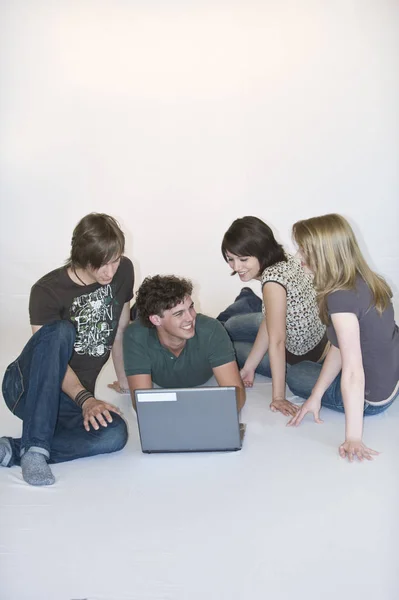 Quatro Jovens Arrepiando Laptop — Fotografia de Stock