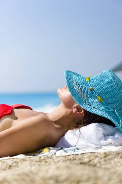 戴帽子的女人躺在阳光下 — 图库照片