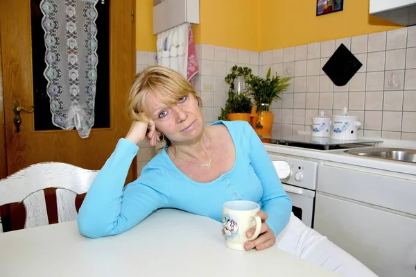 Müde Hausfrau Sitzt Mit Einer Tasse Kaffee Küchentisch — Stockfoto