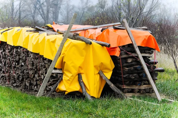 storage space for wood with colorful tarpaulins