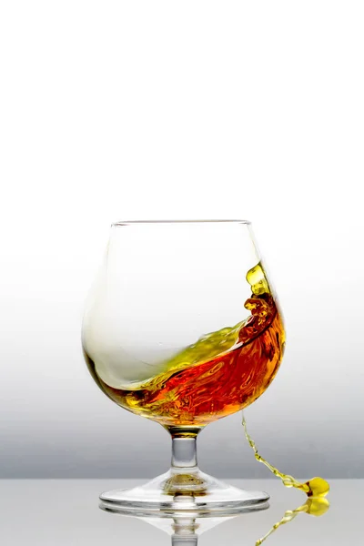 Cognac Spritzt Aus Einem Glas Auf Den Tisch — Stockfoto