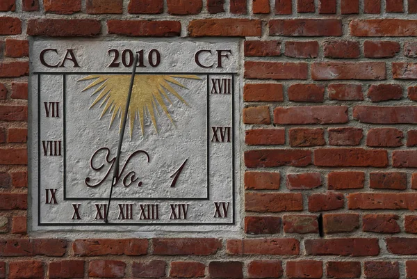 photo of a brick wall with a sign of the zodiac