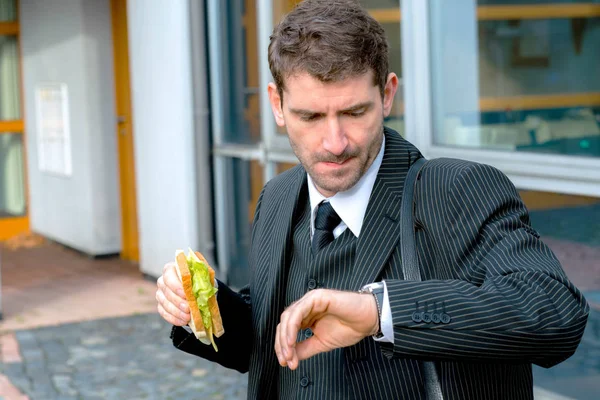 Şehrin Önündeki Takım Elbiseli Adamı Yemek Yiyor Zaman Arıyor — Stok fotoğraf