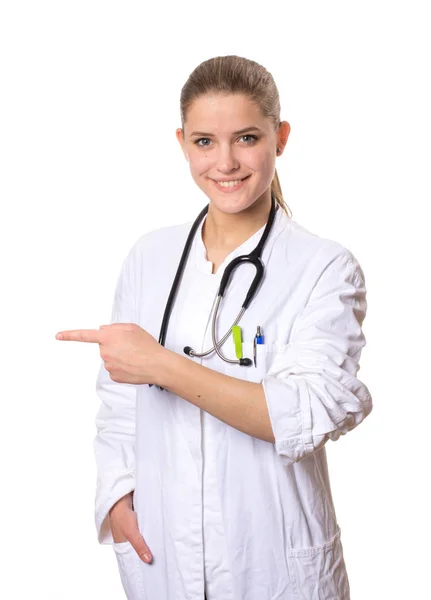 Beyaz Önlüklü Bayan Doktor Kameraya Gülümsüyor Işaret Parmağıyla Solu Işaret — Stok fotoğraf