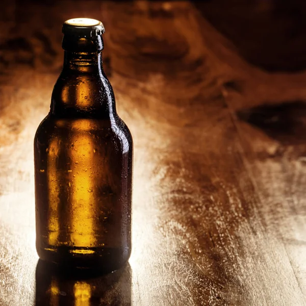 Unlabeled Unopened Brown Bottle Cold Beer Standing Wooden Bar Counter — Stock Photo, Image